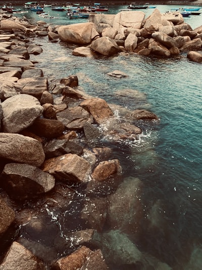 在白天的棕色岩石旁边的水域
